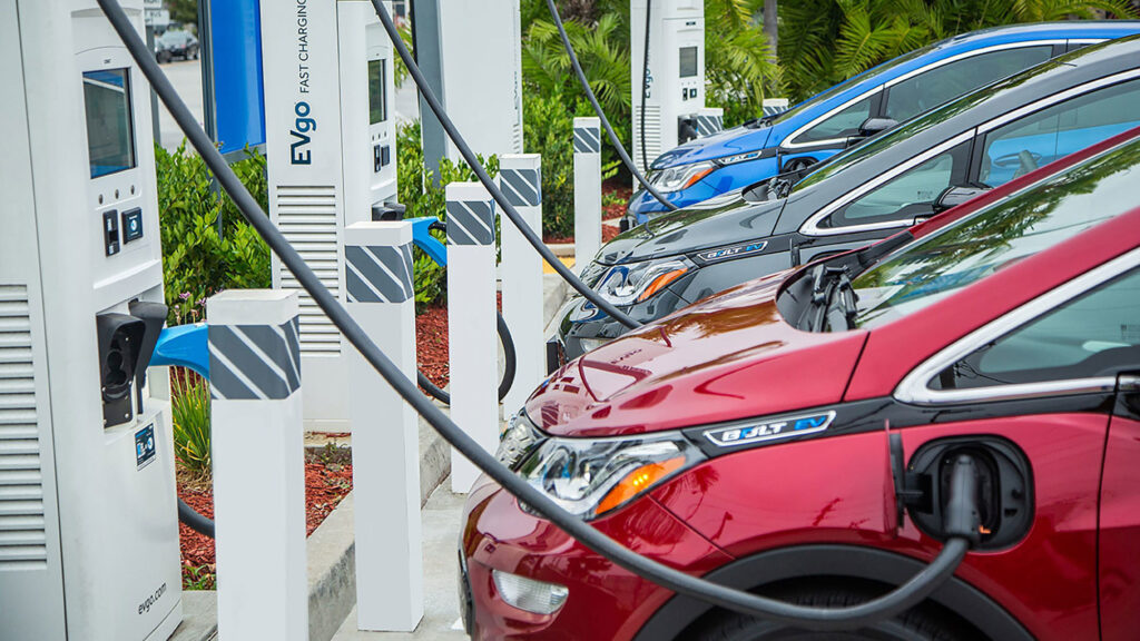 The image explains, the EV Cars are parked in a charging station and are being charged.
