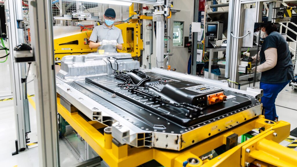 The image is of employees in the factory designing EV Cars.